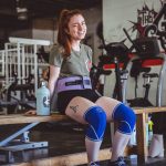woman sitting on brown wooden bench at the gym